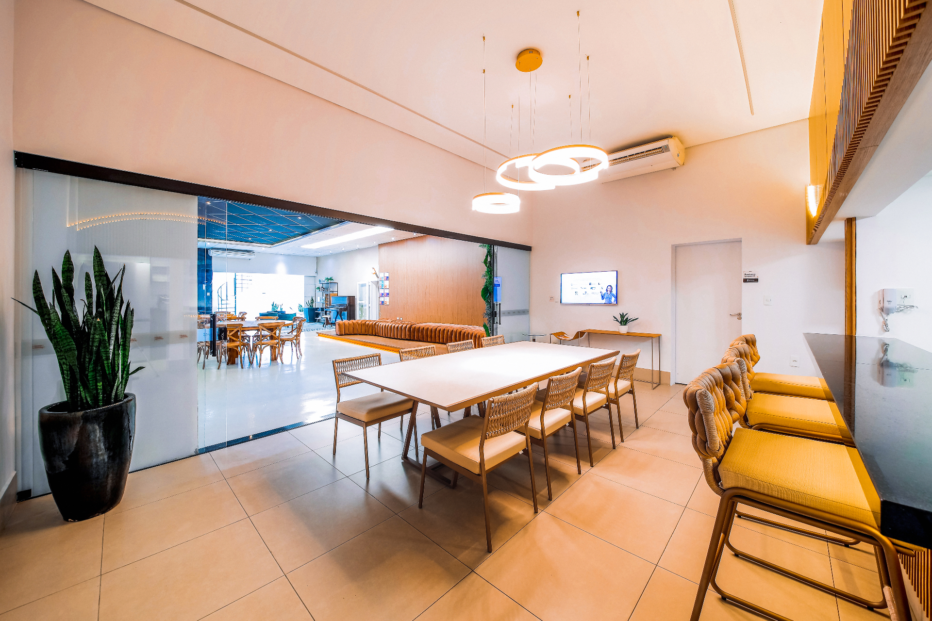 Ambiente de apoio com mesa integrada e vista para o salão do Espaço Multi